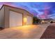 Property with a large auxiliary garage, spacious driveway, desert landscaping, and inviting front yard at 23040 W Hammond Ln, Buckeye, AZ 85326
