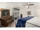 This main bedroom shows a decorative bed frame, sitting area, and ceiling fan at 23040 W Hammond Ln, Buckeye, AZ 85326