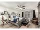This main bedroom boasts a decorative bed frame, ceiling fan, and a sitting area at 23040 W Hammond Ln, Buckeye, AZ 85326
