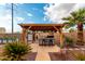 Outdoor covered bar area, barstool seating, a landscaped yard, and a sunny sky above at 23040 W Hammond Ln, Buckeye, AZ 85326