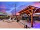 Inviting outdoor kitchen and dining area with a pergola, lounge chairs, and landscaped surroundings at 23040 W Hammond Ln, Buckeye, AZ 85326
