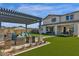 Inviting backyard oasis with a pergola, outdoor seating, and well-manicured lawn at 2541 E Presidio St, Mesa, AZ 85213