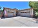Well-maintained home with a three-car garage, brick accents, and covered front porch seating area at 271 W Key West W Dr, Casa Grande, AZ 85122
