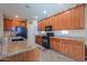 Well-lit kitchen with granite countertops, wood cabinetry, and black appliances at 271 W Key West W Dr, Casa Grande, AZ 85122