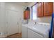 A functional laundry room equipped with white appliances and ample cabinet space at 271 W Key West W Dr, Casa Grande, AZ 85122