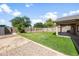 Spacious backyard with an open grassy area, complemented by a shaded patio and mature trees at 40020 N Cape Wrath Dr Dr, San Tan Valley, AZ 85140