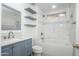 Modern bathroom with tiled walls, floating shelves, white vanity, and gray and white tiled floor at 40020 N Cape Wrath Dr Dr, San Tan Valley, AZ 85140