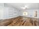 Spacious living room with hardwood floors, built-in shelves, a ceiling fan, and plenty of natural light at 40020 N Cape Wrath Dr Dr, San Tan Valley, AZ 85140