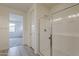 Bathroom featuring a seamless glass shower door and walk-in closet in background at 40030 W Bunker Dr, Maricopa, AZ 85138