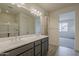 Bathroom featuring a dual sink vanity, recessed lighting, and a glass-enclosed shower at 40030 W Bunker Dr, Maricopa, AZ 85138