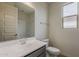 Bathroom featuring a modern single sink vanity, toilet, and tiled shower enclosure at 40030 W Bunker Dr, Maricopa, AZ 85138