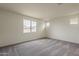 Bedroom featuring soft carpeting, white walls, and several windows allowing natural light at 40030 W Bunker Dr, Maricopa, AZ 85138