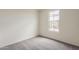 Bedroom with neutral carpeting, a window offering natural light, and a minimalist design at 40030 W Bunker Dr, Maricopa, AZ 85138