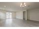 Bright living room with modern light fixture and sliding glass doors at 40030 W Bunker Dr, Maricopa, AZ 85138