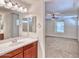 Bathroom with wood cabinets, double sinks, white countertops, mirrors and view to bedroom at 4252 E Vest Ave, Gilbert, AZ 85295