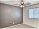 Bedroom with neutral carpet, ceiling fan and textured accent wall with window at 4252 E Vest Ave, Gilbert, AZ 85295