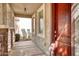 Covered front porch featuring stone columns, decorative lighting, and a solid wood entry door at 4252 E Vest Ave, Gilbert, AZ 85295