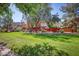 Community green space with lush grass and mature trees, houses in background at 4252 E Vest Ave, Gilbert, AZ 85295