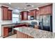Well-equipped kitchen with granite countertops, stainless steel appliances, and cherry wood cabinets at 4252 E Vest Ave, Gilbert, AZ 85295
