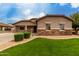 Charming single-story home showcasing appealing stone accents, manicured lawn and desert landscaping at 4255 S Marisol Ln, Gilbert, AZ 85297