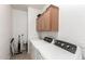 The laundry room features tile flooring, storage cabinets, and a modern, white, side-by-side washer and dryer at 4255 S Marisol Ln, Gilbert, AZ 85297