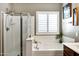 Bathroom featuring a tub, glass shower, and window, providing a bright and airy feel at 4606 S Marron --, Mesa, AZ 85212