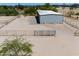 Metal storage building with a covered area, gravel parking, and fenced area for animals at 51089 W Julie Ln, Maricopa, AZ 85139