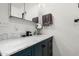 Bathroom vanity with white marble countertop, navy blue cabinets and modern faucet at 51089 W Julie Ln, Maricopa, AZ 85139