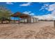Large garage and sheltered parking area in desert landscape under a blue sky at 51089 W Julie Ln, Maricopa, AZ 85139