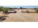Aerial view of the property's expansive lot with a covered structure and workshop at 51089 W Julie Ln, Maricopa, AZ 85139