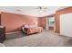 Spacious main bedroom featuring plush carpet, ceiling fan, and a large window for ample natural light at 51089 W Julie Ln, Maricopa, AZ 85139