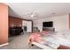 This main bedroom includes neutral walls, plush carpet, ceiling fan, desk, and tv at 51089 W Julie Ln, Maricopa, AZ 85139