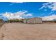Large outbuilding with multiple garage doors, set in a wide open, expansive lot under a bright blue sky at 51089 W Julie Ln, Maricopa, AZ 85139