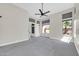 Bright and spacious bedroom featuring large windows, neutral carpeting, and a ceiling fan for comfort at 6041 E Hartford Ave, Scottsdale, AZ 85254