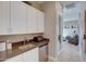 Convenient wet bar equipped with sink, countertop, mini-fridge, and storage cabinets providing functionality and style at 6091 N Sunrise Ln, Buckeye, AZ 85396