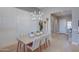 Bright dining room with modern chandelier, white paneled accent wall, and light wood floors at 6091 N Sunrise Ln, Buckeye, AZ 85396