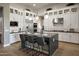 Modern kitchen featuring an island with seating, stainless steel appliances, and white cabinetry at 6091 N Sunrise Ln, Buckeye, AZ 85396