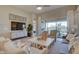 Bright living room with large window, gray sofa, white chairs, and stylish decor at 6091 N Sunrise Ln, Buckeye, AZ 85396