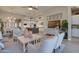 Open concept living room flows into kitchen, featuring white furniture, a ceiling fan, and light wood floors at 6091 N Sunrise Ln, Buckeye, AZ 85396