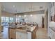 Open-concept kitchen, dining, and living areas with wood floors, modern lighting, and backyard access at 6091 N Sunrise Ln, Buckeye, AZ 85396