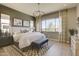 Elegant bedroom featuring a chandelier, large window, and neutral decor for a serene retreat at 6091 N Sunrise Ln, Buckeye, AZ 85396