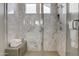 Modern shower with glass door, marble tile, and built-in bench offering a luxurious bathing experience at 6091 N Sunrise Ln, Buckeye, AZ 85396