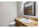Bathroom featuring a wooden vanity, granite countertop, modern sink, and a toilet maximizing space at 6912 N 19Th St, Phoenix, AZ 85016