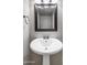 Elegant bathroom with a pedestal sink, classic faucet, and a modern mirror enhancing the bright space at 6912 N 19Th St, Phoenix, AZ 85016