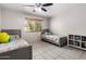 Bright bedroom featuring two twin beds, tiled flooring, a window with blinds, and modern gray furniture at 6912 N 19Th St, Phoenix, AZ 85016
