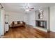 Cozy living room featuring wood floors, a ceiling fan, and a fireplace with a warm, inviting ambiance at 6912 N 19Th St, Phoenix, AZ 85016