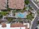 Aerial view of a community pool, hot tub, palm trees, walkways, and buildings with tile roofs at 7275 N Scottsdale Rd # 1001, Paradise Valley, AZ 85253