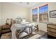 Comfortable bedroom with a wrought iron bed frame, two windows and light-colored walls and ceiling at 7275 N Scottsdale Rd # 1001, Paradise Valley, AZ 85253