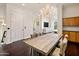 Elegant dining room featuring a rustic wooden table, crystal chandelier, and built-in cabinets at 7275 N Scottsdale Rd # 1001, Paradise Valley, AZ 85253