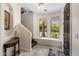 Well-lit foyer with tile flooring, curved walls, decorative niche, dark wood door, and staircase at 7275 N Scottsdale Rd # 1001, Paradise Valley, AZ 85253